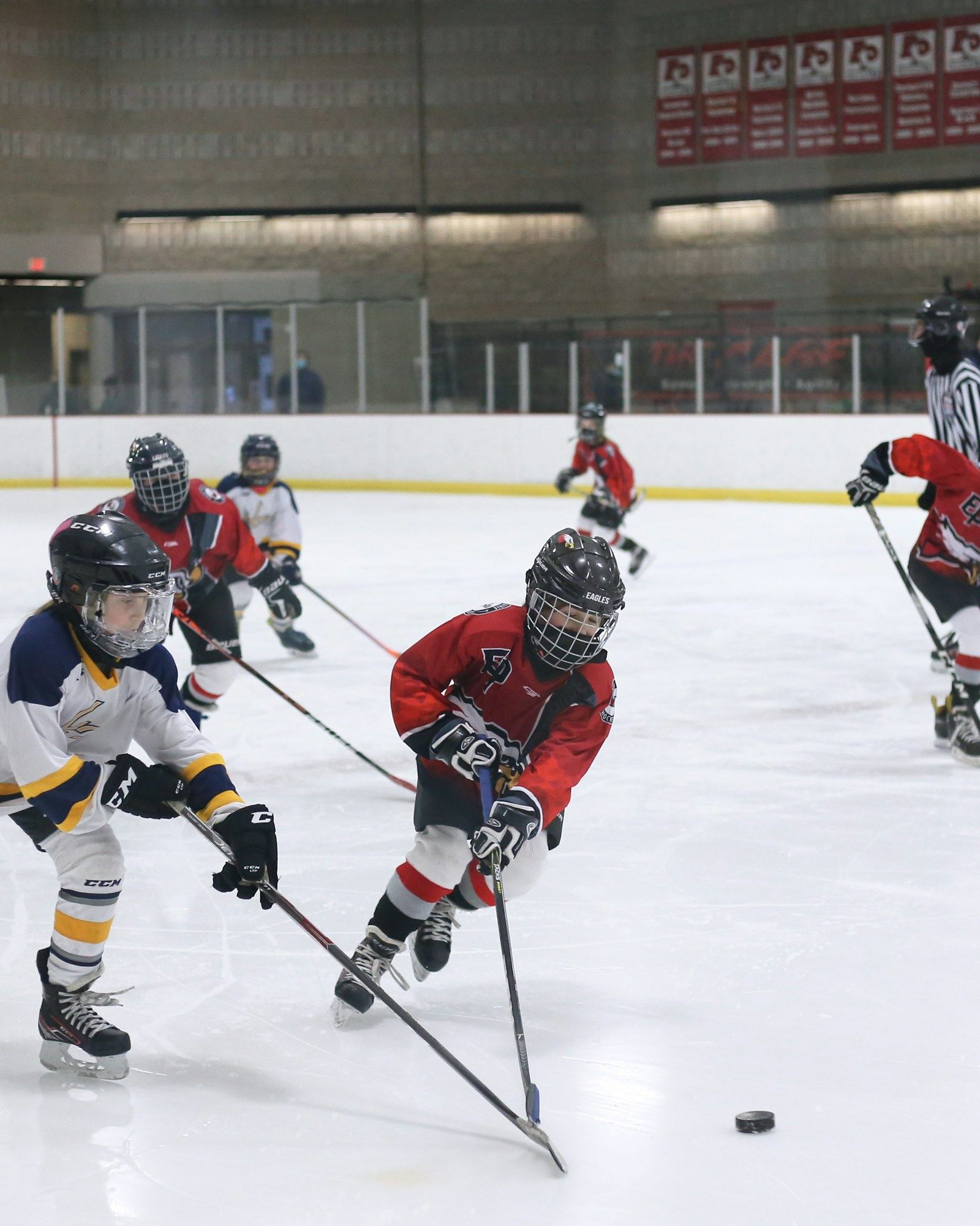 Entraîneur de hockey mineur donnant des consignes à son équipe sur la patinoire